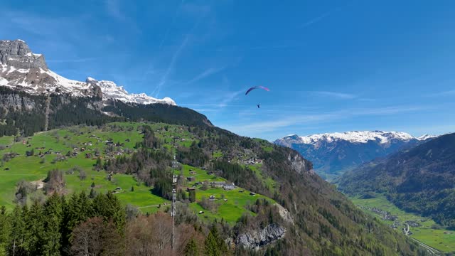 Aerial view of a person paragliding at Braunwald, Switzerland.