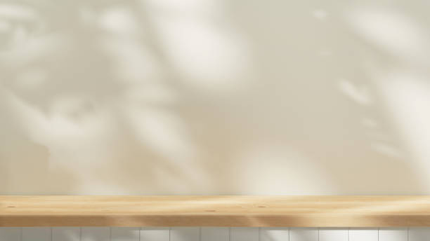 istock Empty wooden countertop mock up to present product and for text design. background summer mock up with tree and leafs shadows and sunlight from window. cozy wooden table and pastel plaster wall 1525838976
