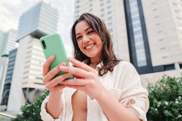 istock Joyful young lady using a mobile phone to do online shopping or having video call. Entrepreneur woman having fun with her cellphone watching the social media, sending messages or browsing on internet 1525938421