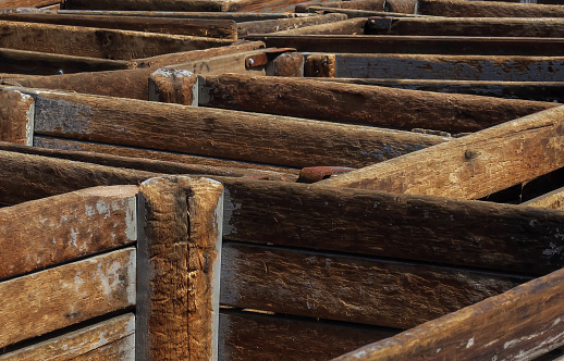 close up of a large group of old and weathered wooden crates made with joined planks, used to hold merchandise outside at a junkyard, Long Island, New York