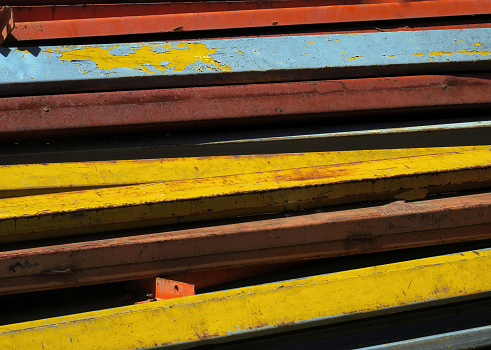 close up of  a retail display of a pile of old, weathered, colorful metal stanchions for sale at a junkyard, Long Island, New  York