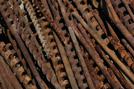 close up of a retail display of old and rusted industrial and agricultural sized drill bits for sale at a salvage yard, Long Island, New York