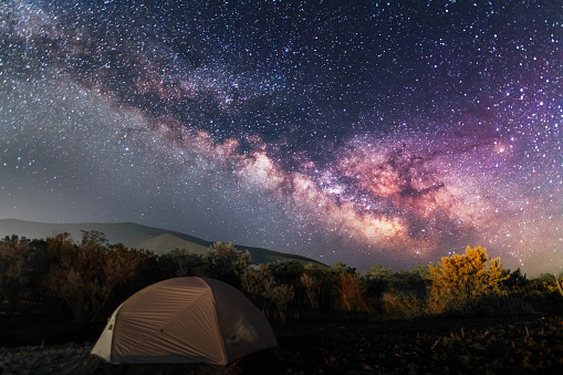 Camping on the beach, tent in the night with bright milky way galaxy.