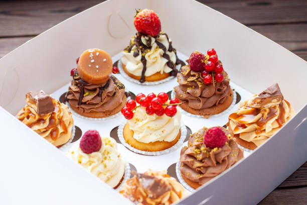 istock Vanilla, chocolate and peanut butter cupcakes with salted caramel, fresh raspberry, strawbeery and red currant in gift paper box 1526070252