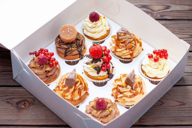 istock Vanilla, chocolate and peanut butter cupcakes with salted caramel, fresh raspberry, strawbeery and red currant in gift paper box 1526070265