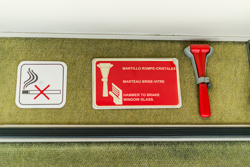 Lisbon, Portugal - July 26 2016: Glass hammer and no smoking sign in a train coupe.