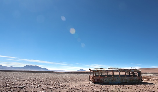 Desert of the Bolivian altiplano, with an old abandoned bus