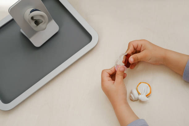 istock Child holding hearing aids in hands. Top view 1526202842