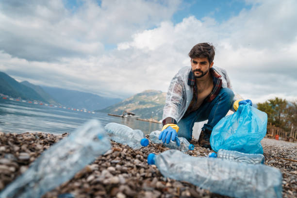 istock Confident man cleaning up the beach from plastic waste 1526216298