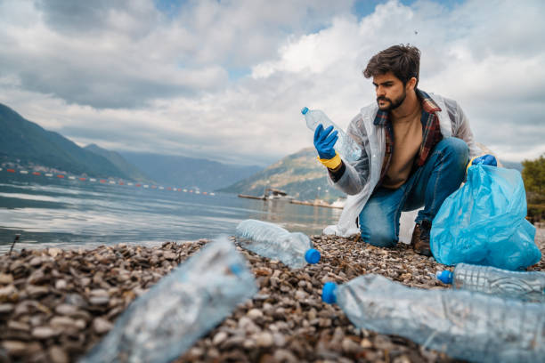 istock Serious man cleaning the garbage from the beach 1526216766