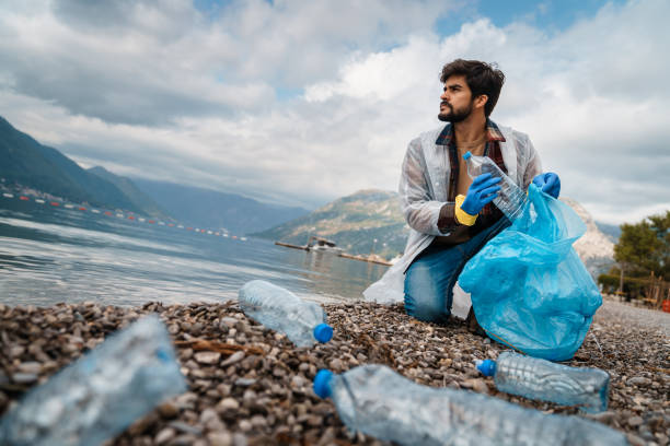 istock Male volunteer cleaning the beach 1526216807