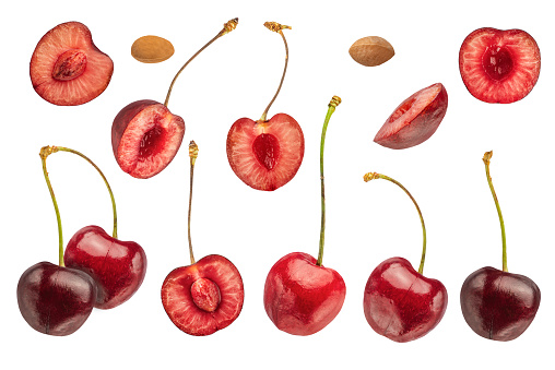 A large set of different cherries on a white isolated background. Cherries from different sides, divided into halves with and without pits on a white background. High quality photo