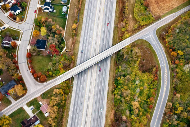 istock Aerial View of a Multi-lane Interstate with an State Route Overpass Leading Into a Subdivision 1526372440