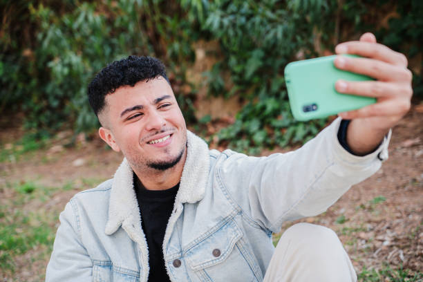 istock One handsome joyful guy taking a selfie portrait with his mobile phone sitting at campus. Happy young teenage student talking on a video conference call conversation with a cellphone social media app 1526390069