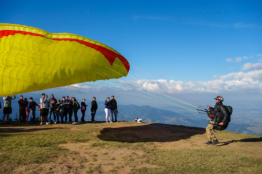 Santo Antonio do Pinhal, SP - Paraglider taking off from Pico Agudo peak, with spectators