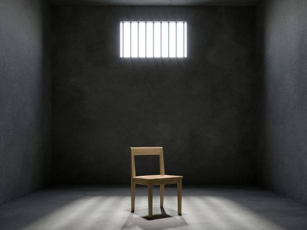 istock chair in prison cell with light shining through a barred window, 3d rendering 1526529127