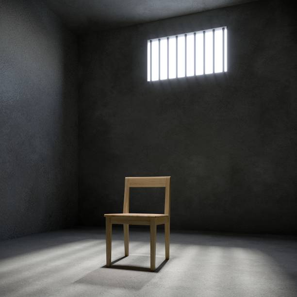 istock chair in prison cell with light shining through a barred window, 3d rendering 1526529133