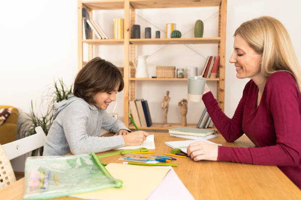 istock Happy woman helping her boy with homework 1526545814