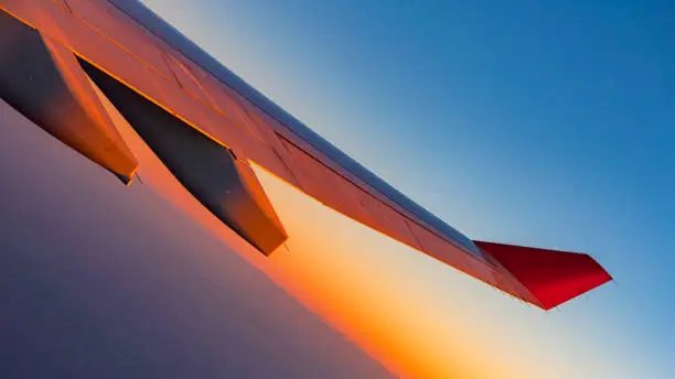 looking at aircraft wing view from windows at sunrise