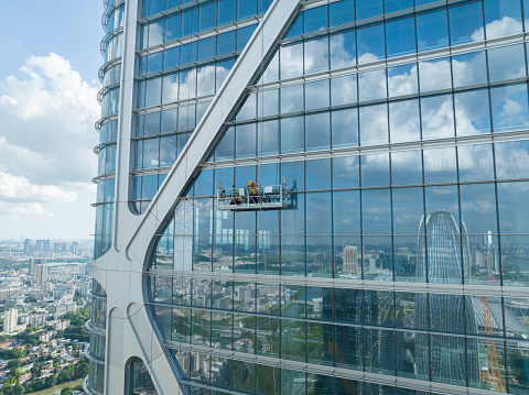 Workers overhauling high-rise glass