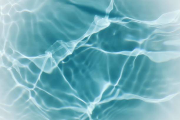 istock Blue water with ripples on the surface. Defocus blurred transparent blue colored clear calm water surface texture with splashes and bubbles. Water waves with shining pattern texture background. 1526651759