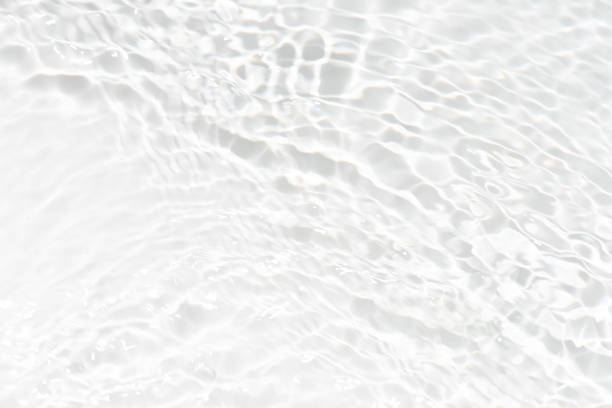 istock White water with ripples on the surface. Defocus blurred transparent white colored clear calm water surface texture with splashes and bubbles. Water waves with shining pattern texture background. 1526759009