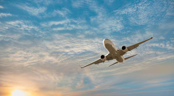avión volando sobre mar tropical al atardecer - avión de pasajeros fotografías e imágenes de stock