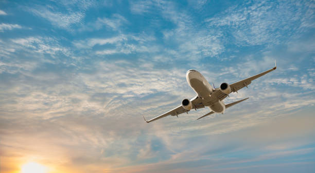 avión volando sobre mar tropical al atardecer - air vehicle fotografías e imágenes de stock