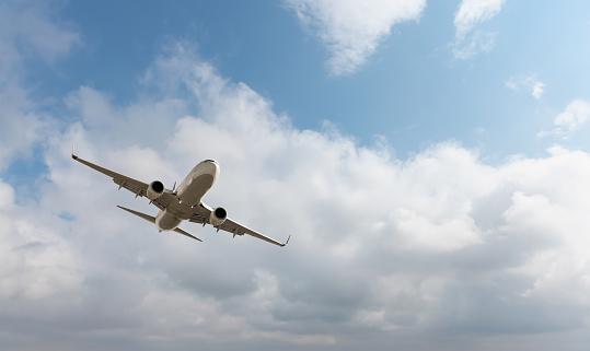 White passenger airplane flying in the sky amazing clouds in the background - Travel by air transport