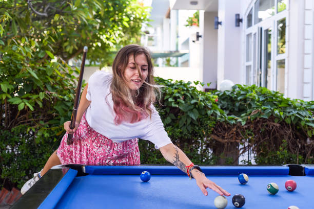 istock Young blond woman playing billiards in the backyard 1527032357