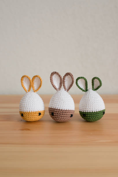 istock Handmade crochet easter bunnies on wooden table and white background 1527114617