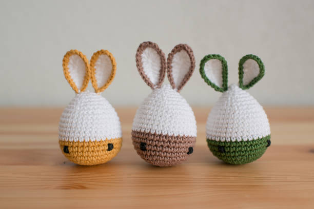 istock Handmade crochet easter bunnies on wooden table and white background 1527114622