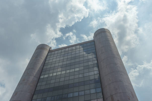 istock Old office commercial building with transparant windows and rounded pillar in sunny cloudy blue sky afternoon 1527123893