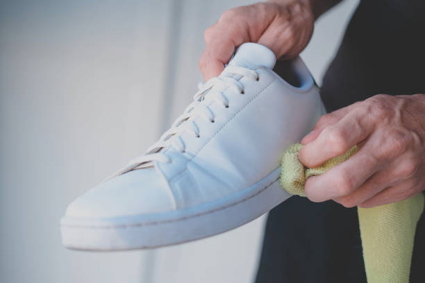istock A man cleans white sneakers from dirt 1527370485