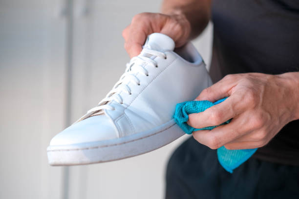 istock A man cleans white sneakers from dirt 1527372551