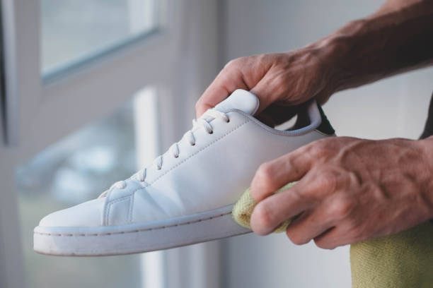 istock A man cleans white sneakers from dirt 1527372552
