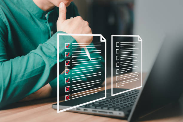 istock Adult man using laptop computer with virtual screen contact questionnaire with checkbox. Assessment knowledge test concept, fill out application form, online exam, quiz knowledge and online learning. 1527485953