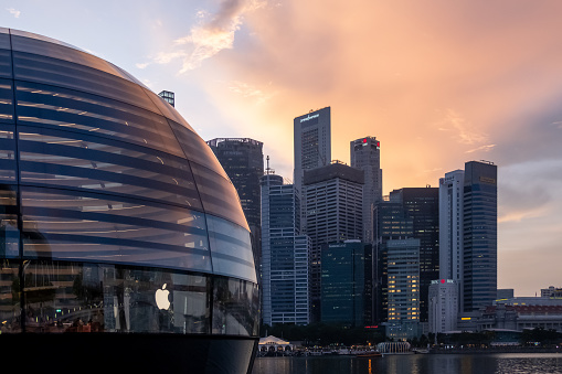 Singapore - 20 October 2022: Apple Marina Bay Sands with sunset sky. The World's First Floating Apple Store, designed by Foster + Partners.