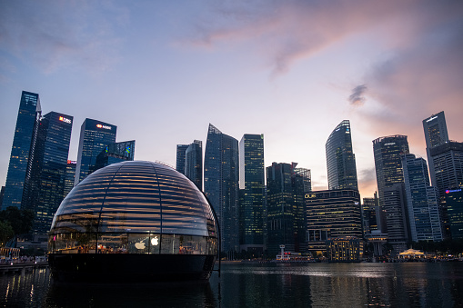 Singapore - 20 October 2022: Apple Marina Bay Sands with sunset sky. The World's First Floating Apple Store, designed by Foster + Partners.