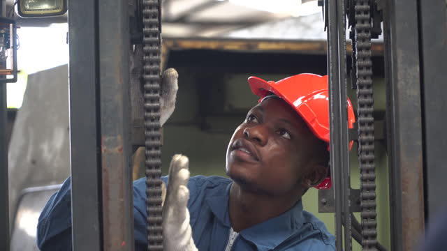 african american Mechanical engineer maintenance forklift in factory . black worker man repairing machine in warehouse Workshop