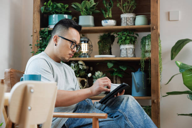 istock Asian  man working on a digital tablet at home 1527526494