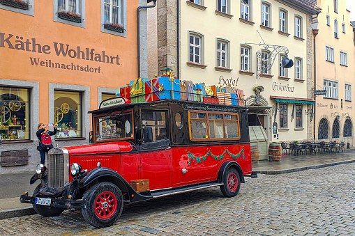Rothenburg ob der Tauber, Bavaria: Vintage and funny Santa's car with gifts, in well-preserved medieval old town, part of the Romantic Road through southern Germany.