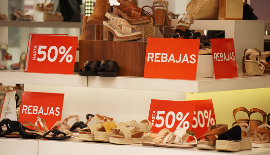 a counter of summer sandals, with signs advertising 50% discounts