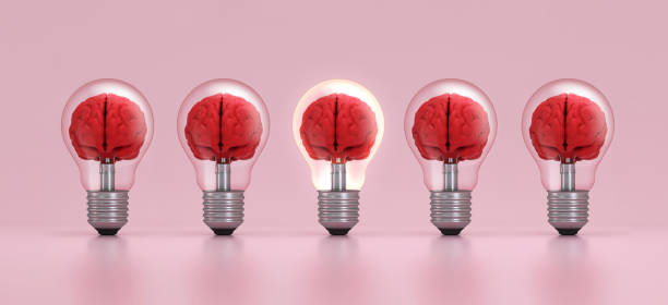 istock Brain inside a light bulb illuminated standing out from the crowd on pink background. Concept of inspiration. 1527540556