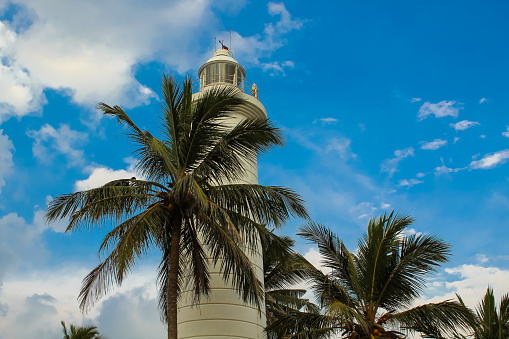 White lighthouse and tropical palms, Galle fortress, Sri Lanka. Horizontal image with copy space