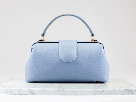 Luxury women 's bag. Luxury ice blue leather handbag on white background, on marble floor. A elegant bag. Fashionable trendy