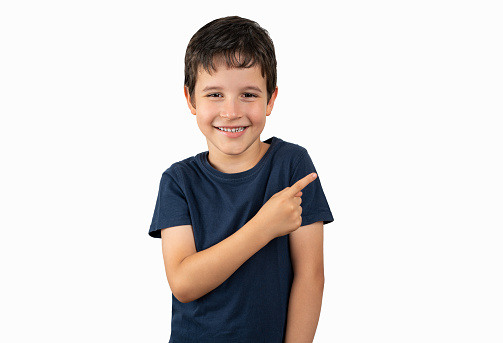 Little boy over isolated background smiling and looking at the camera pointing with one hand and fingers to the side.