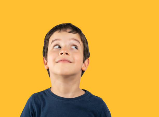 istock little boy looking up askance and smiling 1527624077