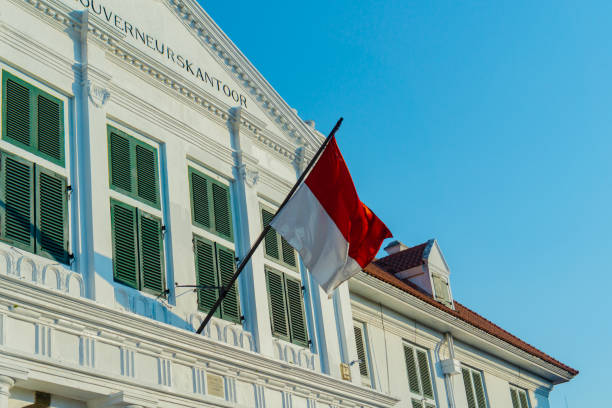 Indonesian flag above the building Indonesian flag fluttering above white retro building jakarta slums stock pictures, royalty-free photos & images
