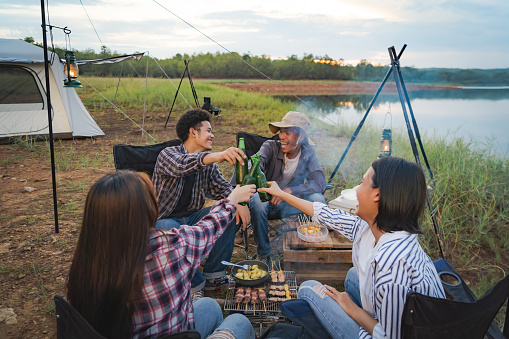 Camp party in the evening with a bonfire. Have fun cooking barbecued food.